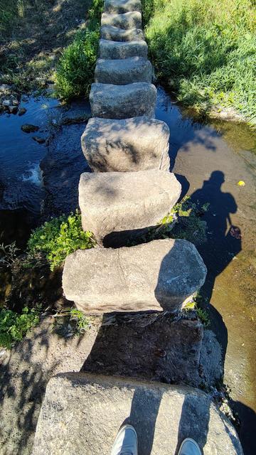 A path of stepping stones over a small river currently carrying little water.