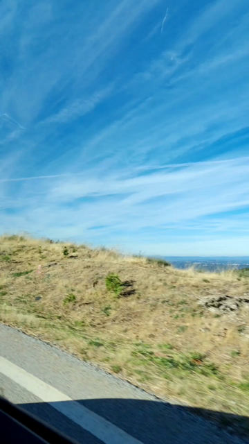 A montage of small clips taken on a tour through the Serra da Estrala mountains. It includes footage of the views over the valley, the tour guide and some old shepherd houses from the area. It's daytime and sunny. The sky is blue.