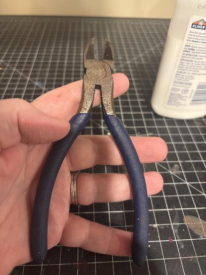 a persons hand holding wire cutters